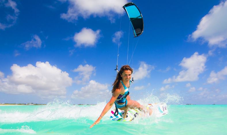 Chica practica kitesurfing.