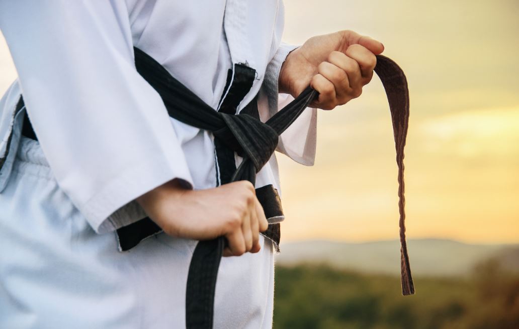 Persona se ajusta el cinturón negro de judo.