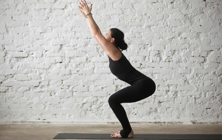 Otra de las posturas de yoga para mejorar el levantamiento de pesas es el Utkatasana o postura de la silla. 