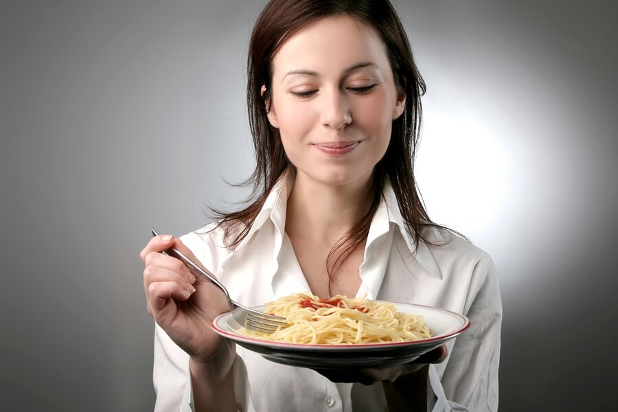 Mujer consume carbohidratos, los cuales son muy importante para el balance de energía.
