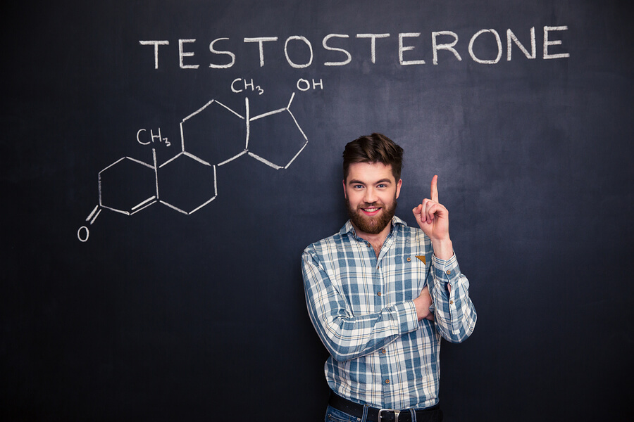 Hombre señalando hormona testosterona escrita en pizarrón