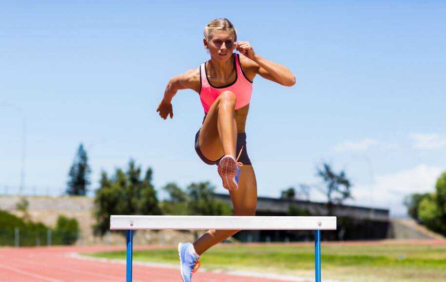 Mujer saltando obstáculo para representar cómo es el cerebro de un atleta.