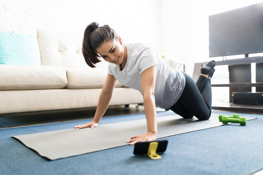 Mujer mirando canales de fitness para hacer ejercicios en casa.