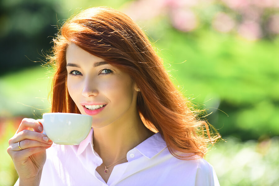 Mujer tomando café verde con el objetivo de adelgazar.