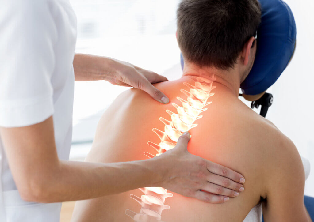 Fisioterapeuta realiza masajes en la espalda de un paciente.