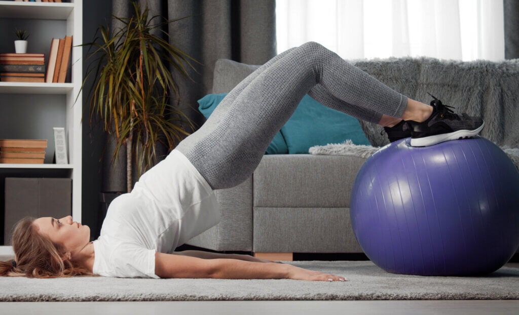 Mujer haciendo ejercicios con pelota de pilates.