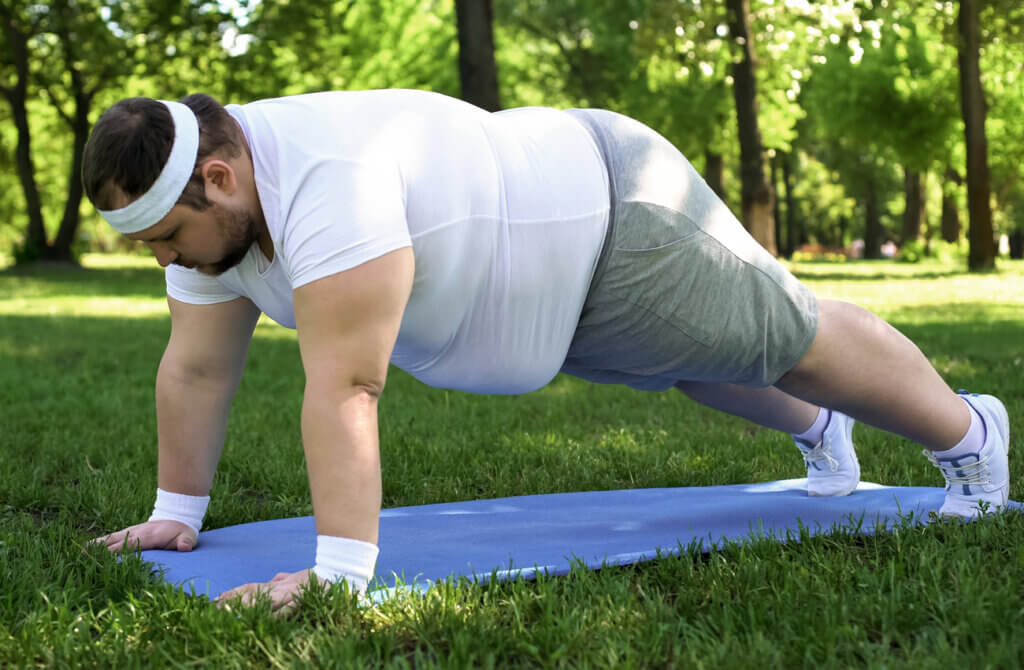 Hombre con sobrepeso realizando una sesión de yoga.