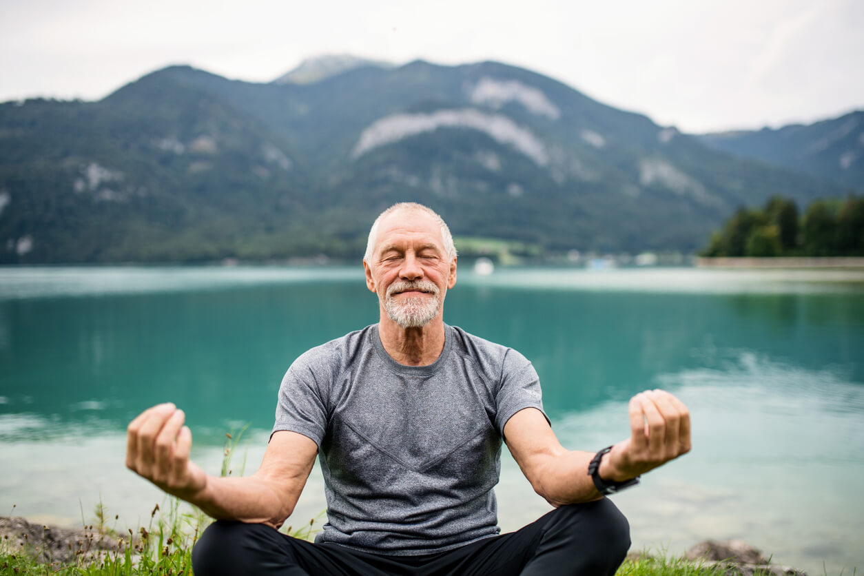 Hombre mayor realizando diversos tipos de meditación al aire libre.