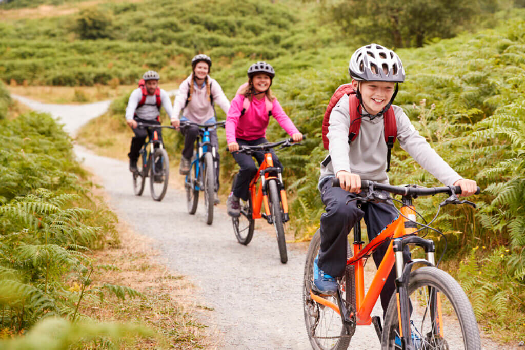 Niños que realizan ejercicio y aprovechan los beneficios del ciclismo de montaña.