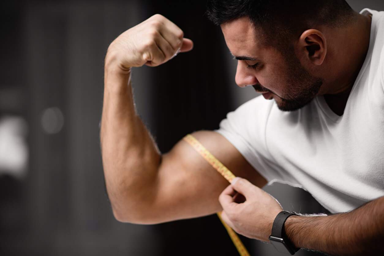 Hombre midiendo su músculo bíceps luego de hacer repeticiones