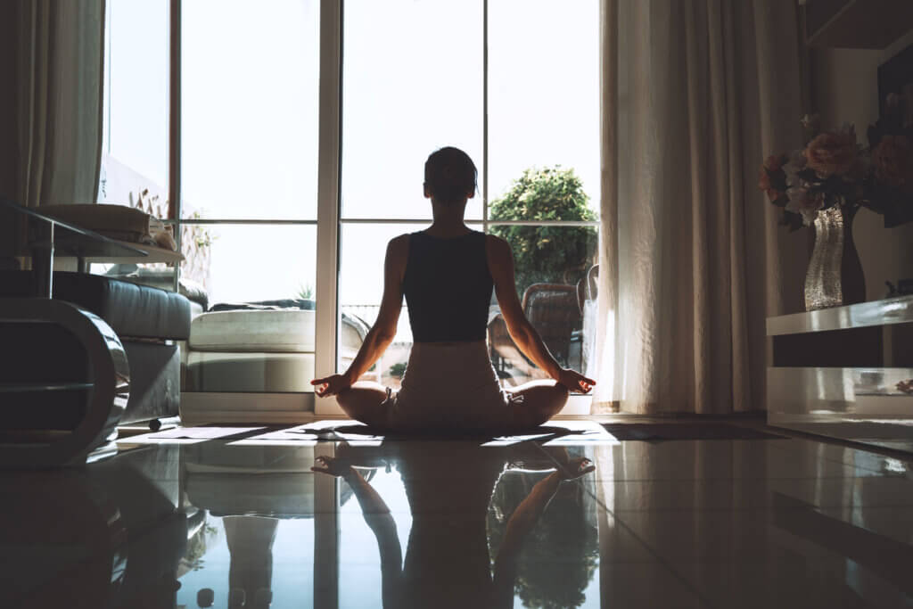 Mujer realizando mindfulness en su casa para aprovechar los beneficios