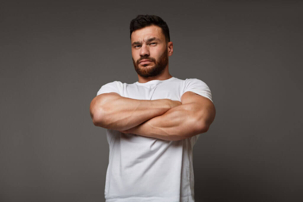 Hombre cruzado de brazos que aumentó su masa muscular con tips nutricionales