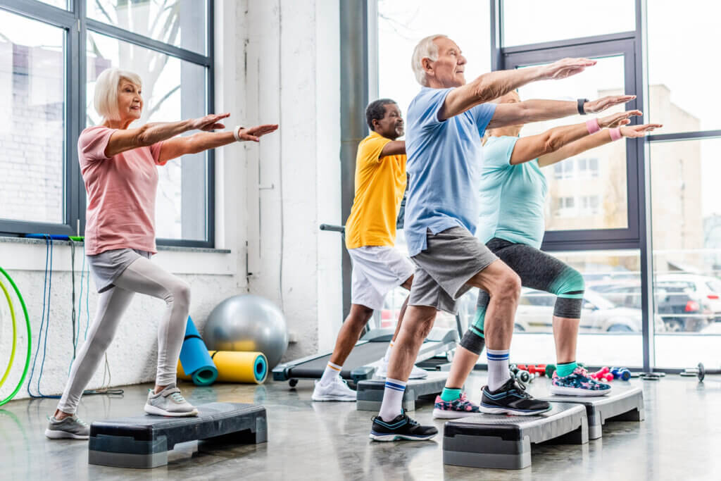 Adultos mayores realizando variantes de ejercicios de cardio sin impacto articular