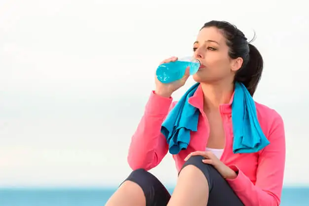 Mujer sentada bebiendo una bebida energética