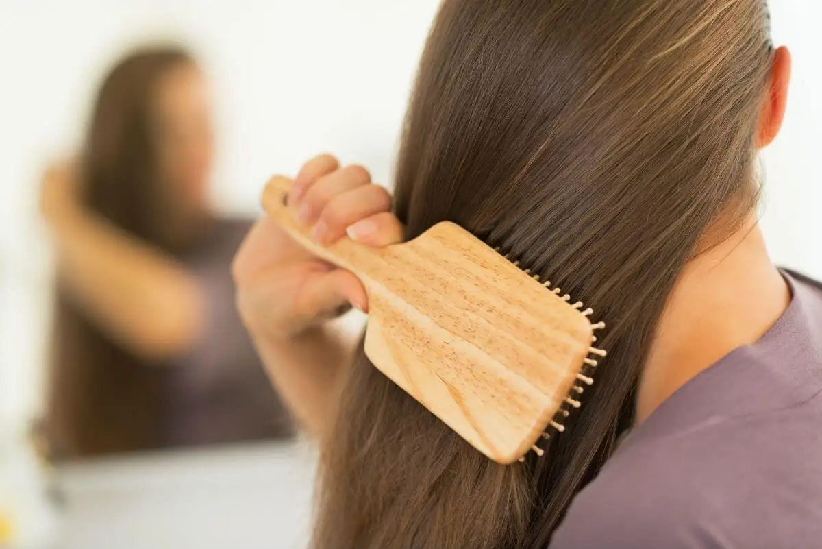 Mujer cepillándose el cabello.