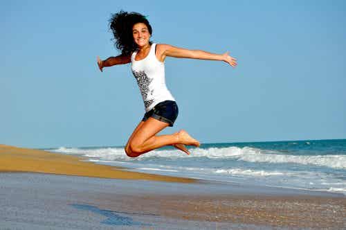 Mujer dando un salto en la playa
