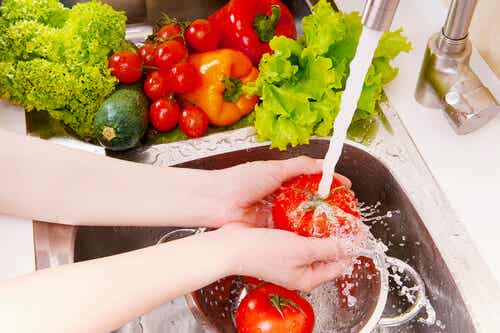 Mujer lavando tomates y verduras