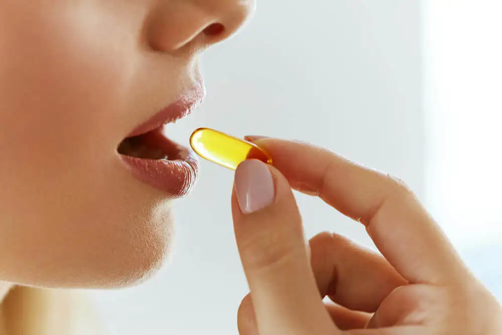 Mujer con una cápsula de vitamina.