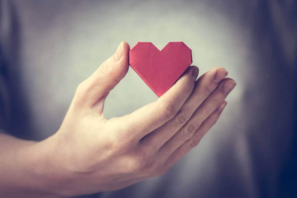 Corazón de papel en la mano