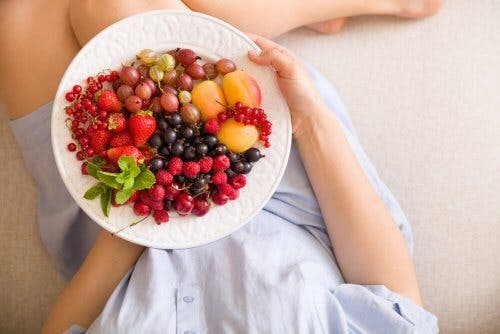 Mujer embarazada con un bol de frutas
