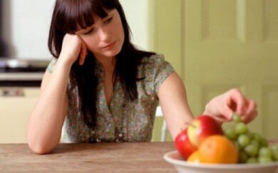 Kvinde rører ved frugter, men har ingen appetit