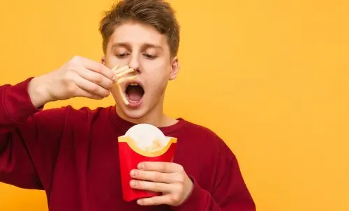 chico comiendo patatas fritas