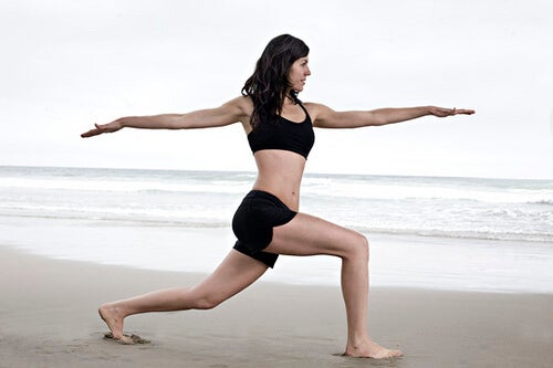 Mujer practicando yoga en la playa