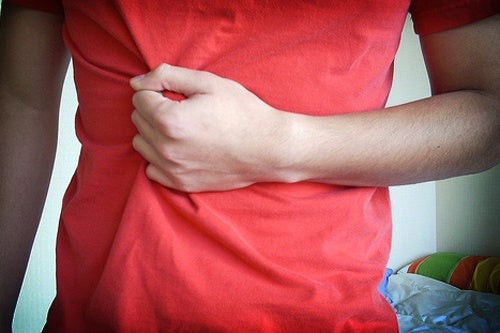 Persona tocándose el abdomen debido a su enfermedad inflamatoria intestinal