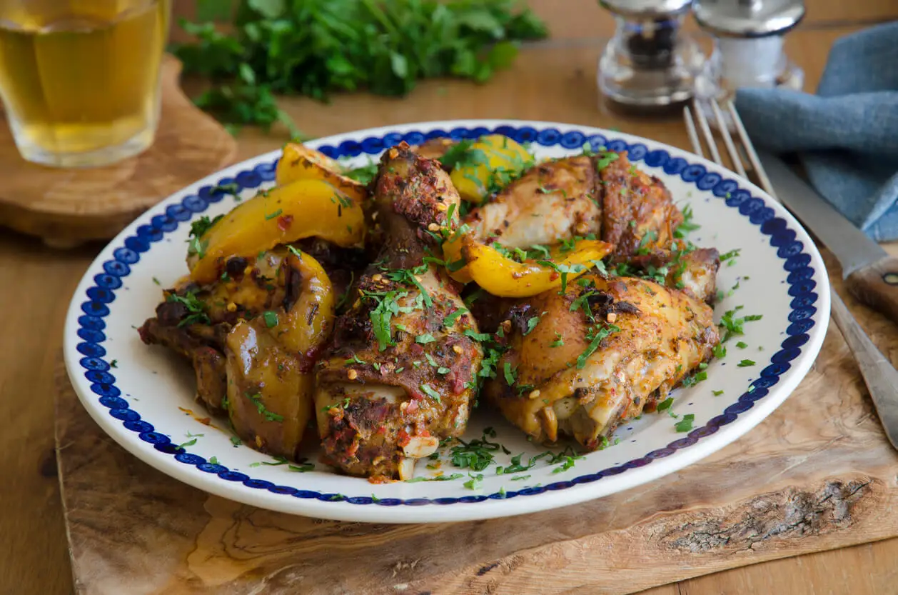Pollo asado con patatas y dátil.