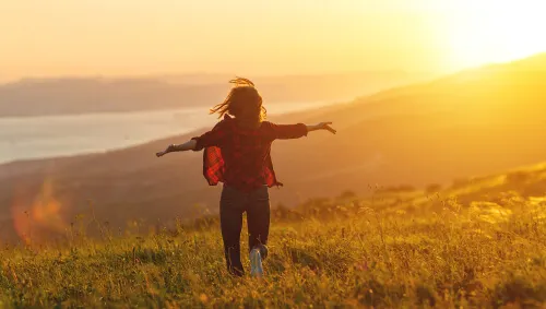 Mujer saltando con los brazos abiertos