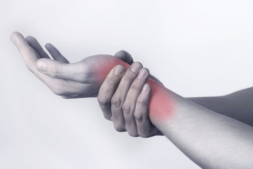 Persona tocándose la muñeca a causa de la artritis que le provoca dolor