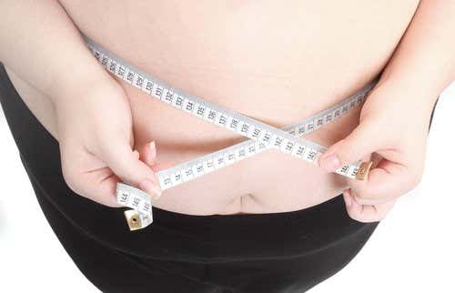 Persona obesa midiendo su cintura