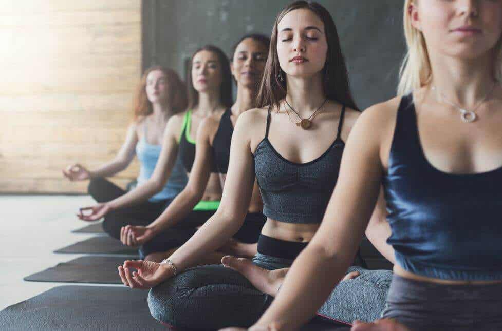 Femmes méditant en cours de yoga.