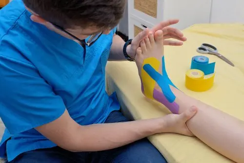 Fisioterapeuta aplicando un vendaje neuromuscular.