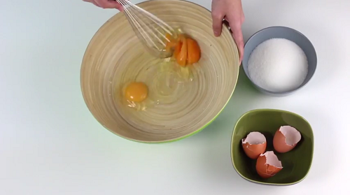 Mujer batiendo huevos para el merengue suizo