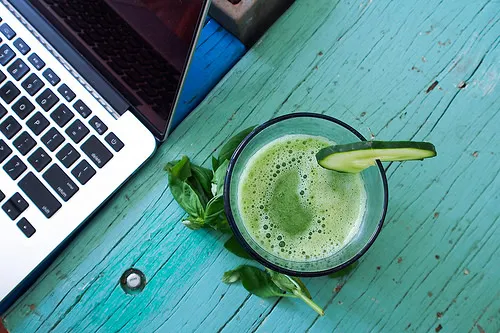 Säfte zur Stärkung des Immunsystems - grüner Saft neben Laptop