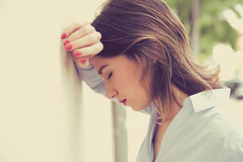 Kvinde hviler hoved mod væg og kæmper med at være træt hele tiden