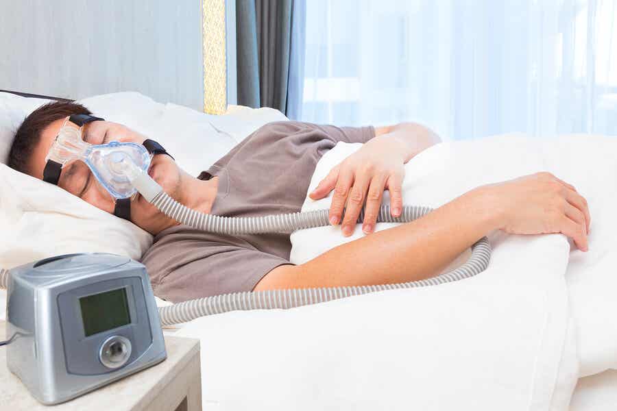Paciente con apnea del sueño durmiendo con una máquina de aire. 