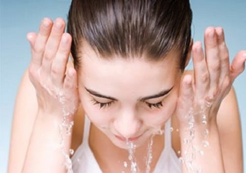 Mujer limpiándose la cara para tener una piel perfecta