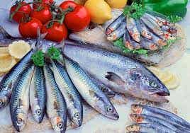 Diferentes pescados exhibidos con verduras