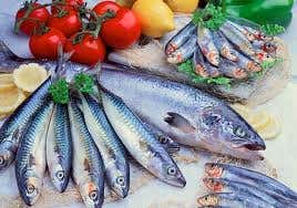 Diferentes pescados exhibidos con verduras