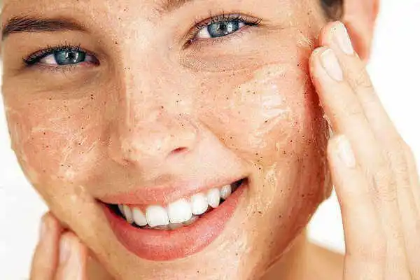 Mujer exfoliándose el rostro para tener piel perfecta
