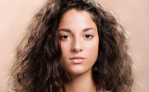Chica guapa con pelo negro, abundante y encrespado.