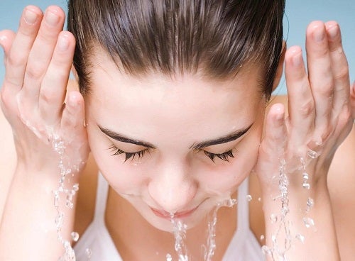 Mujer lavándose la cara.