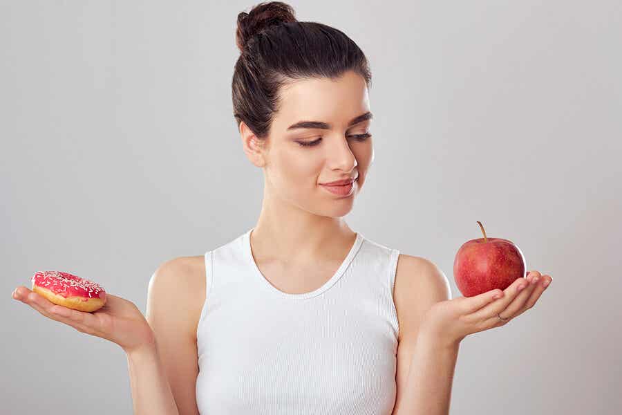 Chica con un donut y una manzana.