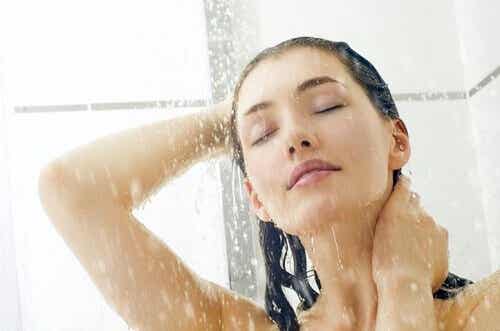 Mujer lavándose el cabello en la ducha.