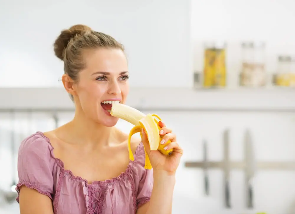 Mujer comiendo plátano.