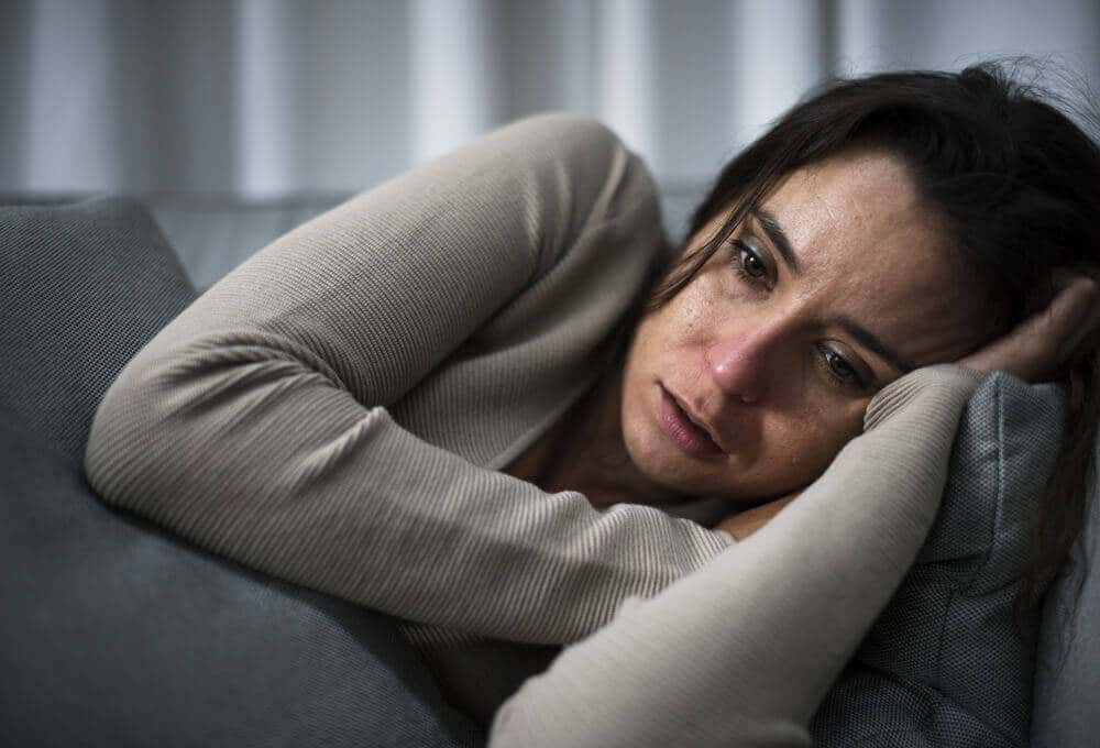 Mujer con depresión llorando en el sofá