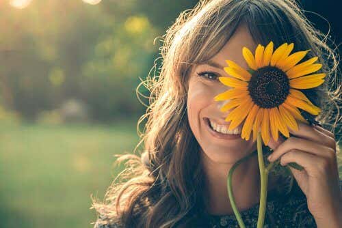 Smilende kvinde med blomst foran øjet, da hun har overvundet sine skygger