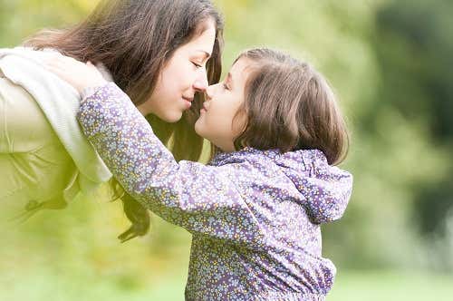 Hija dando un beso a su madre como parte del proceso para reconocer las emociones.
